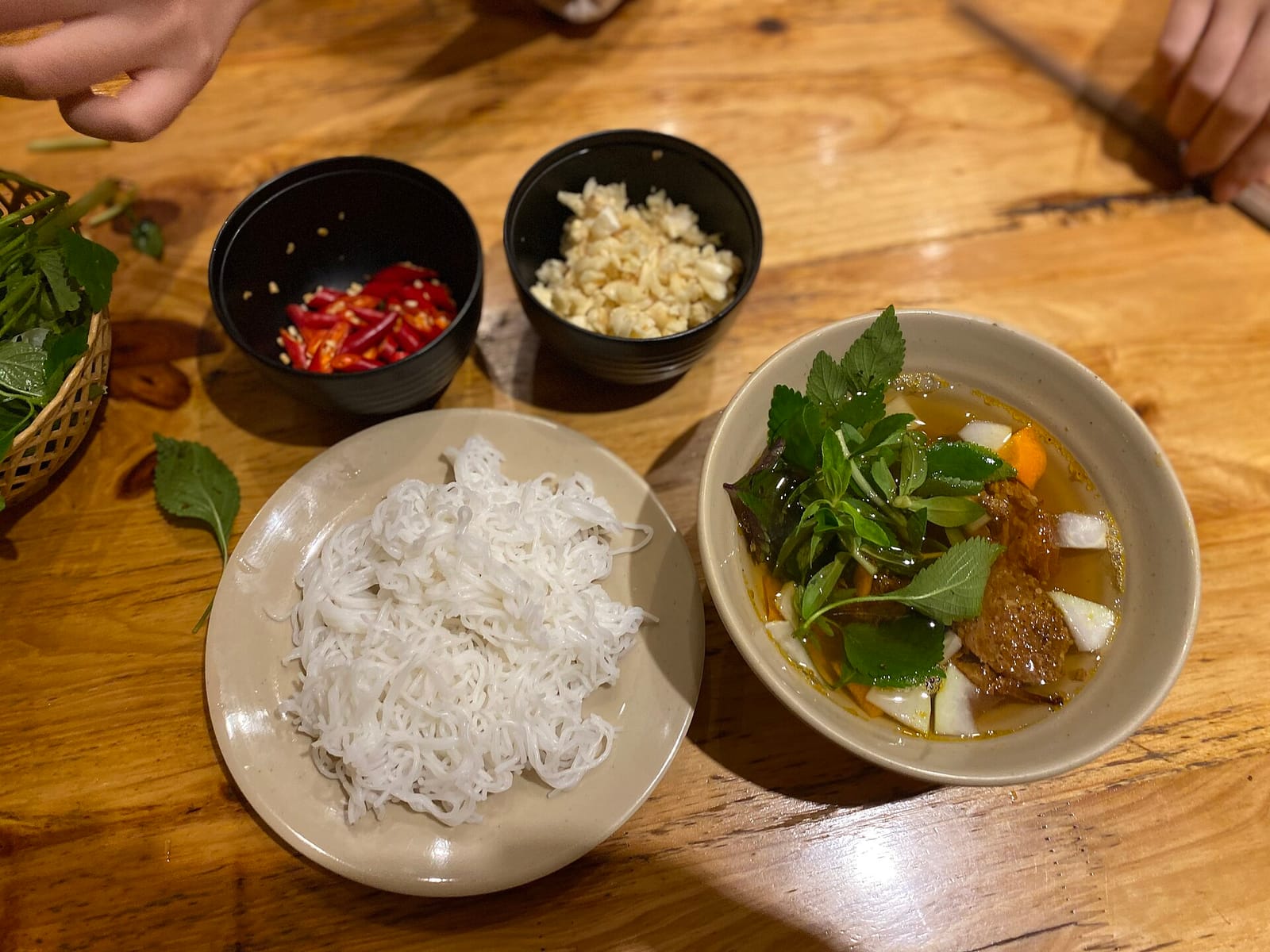 A bowl of bun cha with grilled pork and herbs